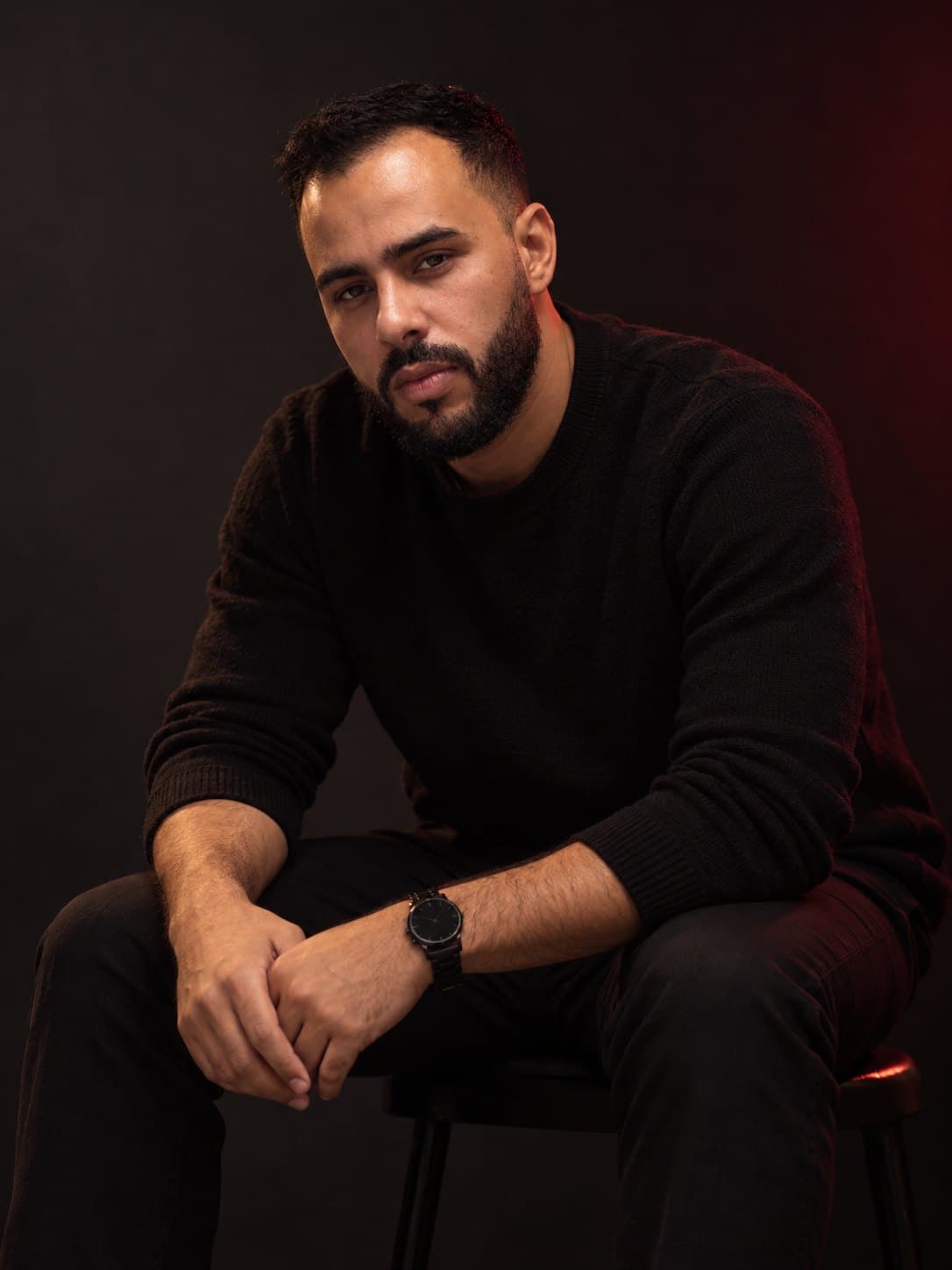 Ayoub Jouini seated in a dark studio, looking at the camera